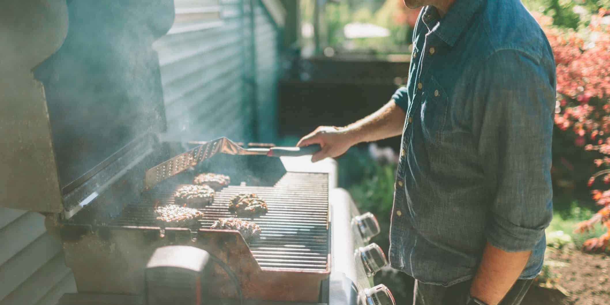 a man barbecuing burgers in the backyard t20 ko9o9P 1